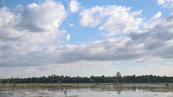 Wide, exterior, Time lapse Shot of White Clouds Drifting Above Flood Plain in Daytime alt