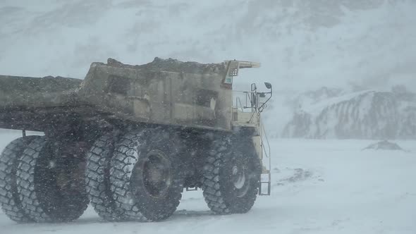 A Dumper Truck Drives Through an Open-pit Coal Mine in Winter