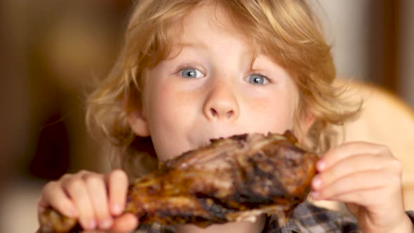 Young Blonde Boy Eating A Grilled Turkey Drumstick