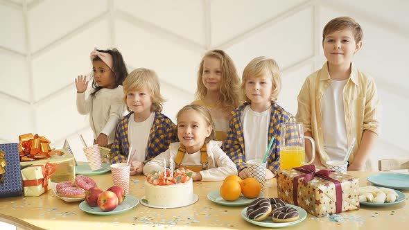 Children Gathered at a Festive Table Around the Birthday Girl alt