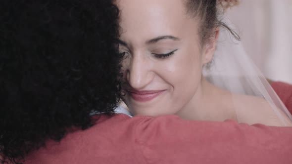 Mother hugging daughter in wedding dress