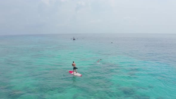 Flycam Films Fit Man Practising Stand Up Paddle on Ocean alt