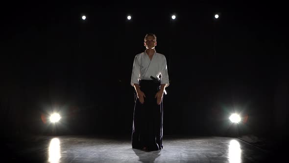 Aikido Master Wearing Traditional Samurai Hakama Clothes Takes His Japanese Sword Out of Scabbard alt