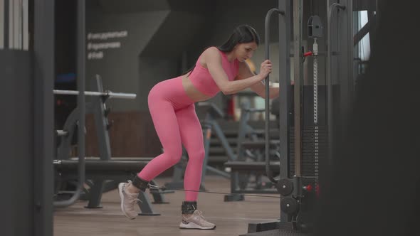 A Young Woman Lifts Her Leg in a Crossover to Train Her Thigh and Leg Muscles alt