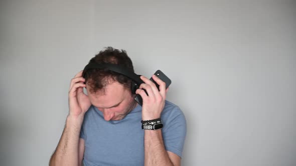 Happy Man Using Mobile Phone While Listening Music on Headphones alt