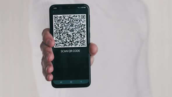 Male Hand Shows QR Code on Smartphone on White Background alt