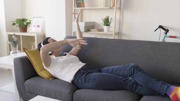 Cheerful Young Adult Woman Listening Her Favourite Song on Wireless Headphones alt