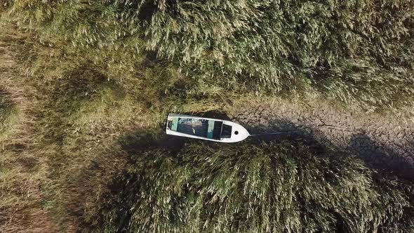 Top View of Boat at Shore of Dried Up Sea Global Warming and Drought Concept alt