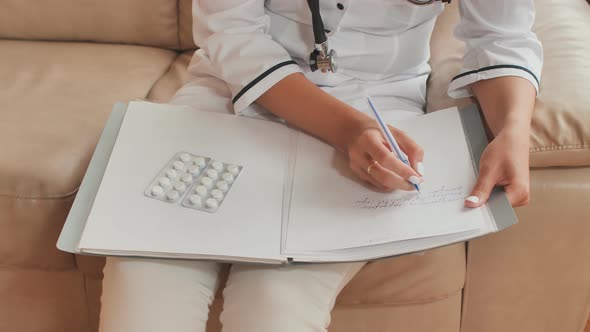 A Young Woman Doctor Writes Prescription Medications and Treatment Advice alt