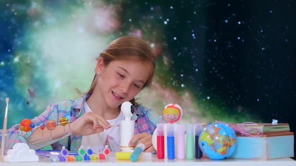 Small Girl Painting a doll Moving Cosmos Background