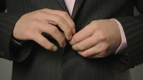 Office Worker in Suit Fastening Upper and Lower Buttons on His Jacket Close Up alt