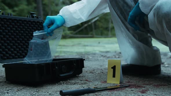 Criminalists Putting Proofs Into Protective Case at Crime Scene Closeup Taking Evidence From alt