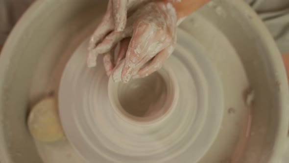 Potter Crafting Earthenware on Pottery Wheel