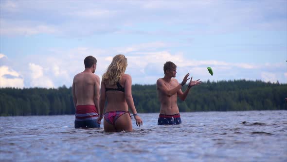 Young adults swimming, bathing and playing in a shallow lake. alt