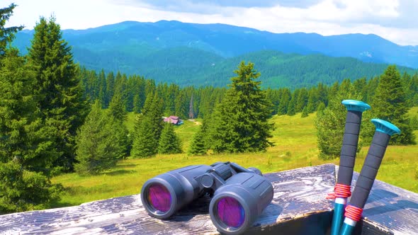 Hiking Sticks And Binoculars On The Wooden Table, Mountain Valley On A Background alt