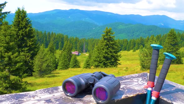 Hiking Sticks And Binoculars On The Wooden Table, Mountain Valley On A Background