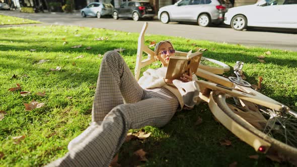 Stylish Woman with Wooden Eco Bicycle Reading a Book in the City Part alt