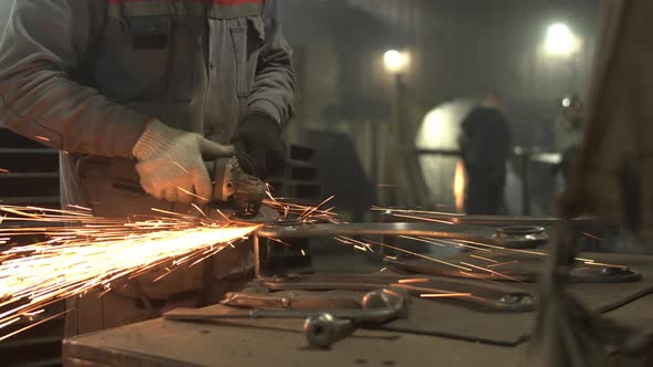 Unrecognizable Male Employee Grinding Metal on Workbench