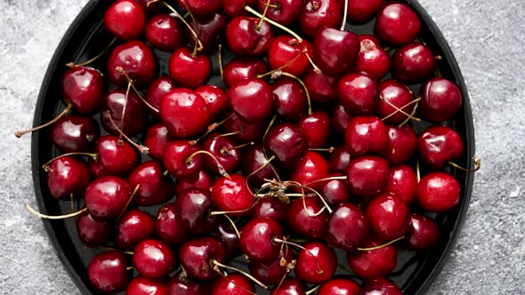 Sweet Fresh Cherry on a Plate on a Stone Background
