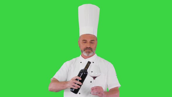 Senior Man Cook Tasting Red Wine on a Green Screen Chroma Key alt