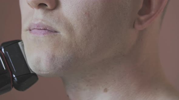 Side View of Part of a Young Man's Face Who is Shaving His Chin
