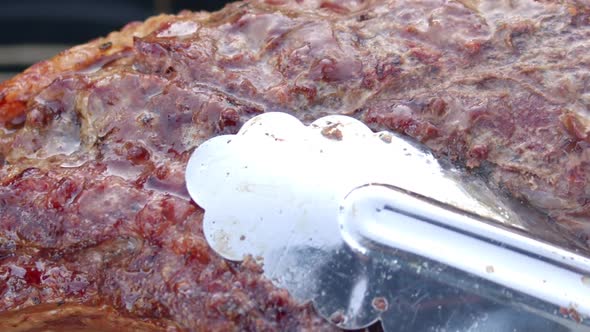 Delicious bubbling meat lifted with a forceps alt