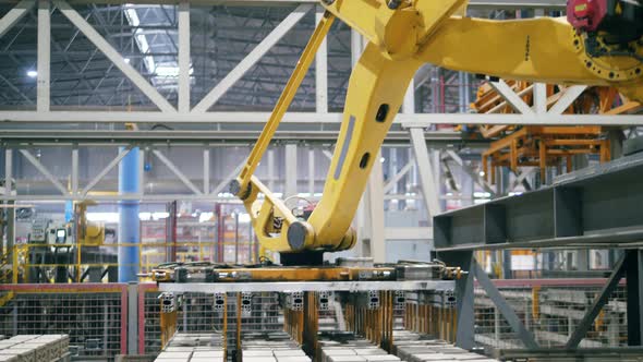 Modern Industrial Factory. Transporting Machine Is Relocating Batches of Bricks alt
