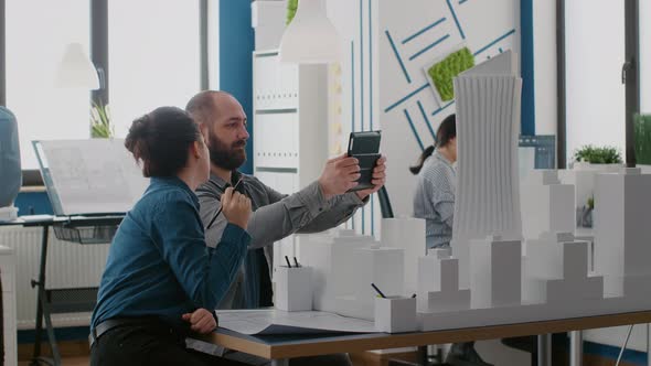 Team of People Working with Digital Tablet and Building Model to Plan Construction Layout alt