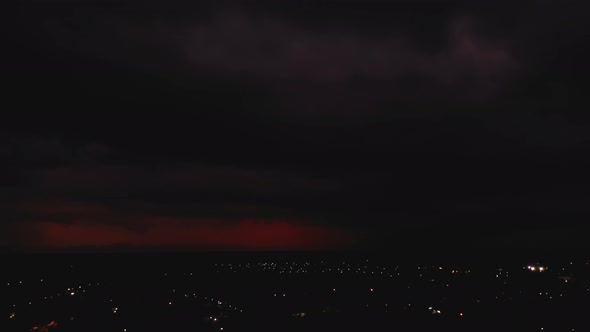 Sliding Aerial Footage of Red Clouds in Sky with Flashing Lightning During Thunderstorm alt