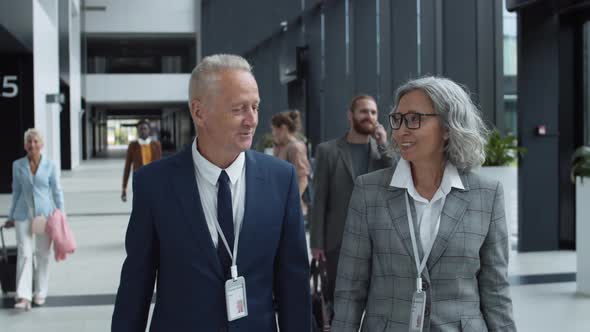 Aged Businessman and Businesswoman in Airport alt
