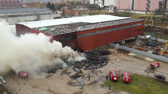 Aerial View of Firefighters Extinguishing Fire in Industrial Area alt