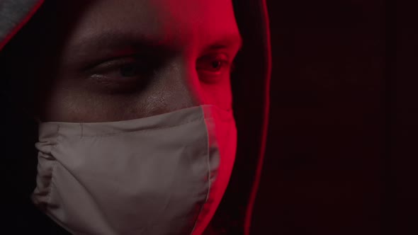 A Man in a Surgical Mask Looks Close-up at the Camera alt