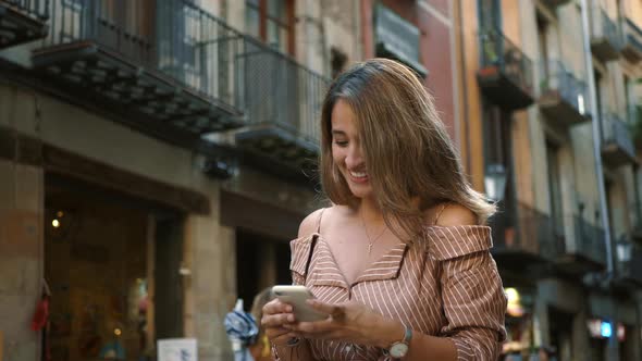 Portrait of Young Woman Looking Mobile Phone. Smiling Girl Scrolling Smartphone alt