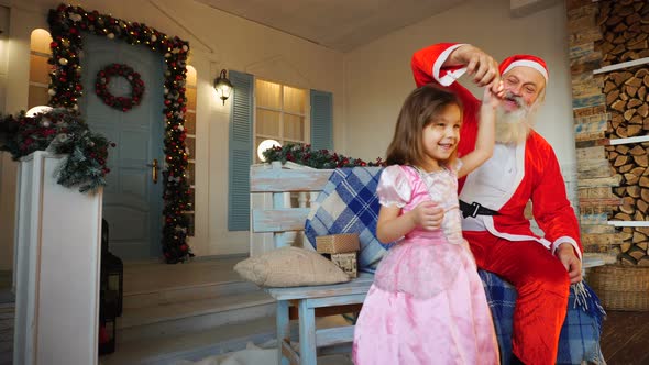 Whirling Little Girl and Cheerful Santa Claus.