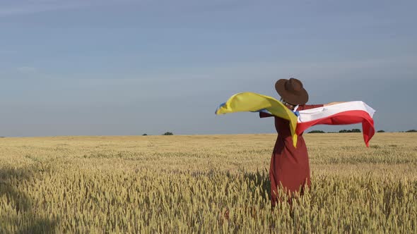 Girl with Ukraine and Poland flags in wheat field and blue sky on background
