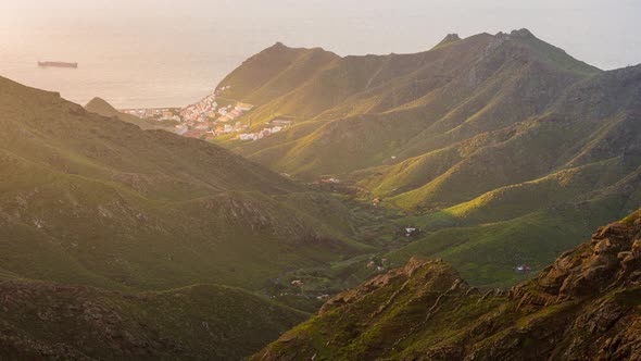 Tenerife Anaga Valley Sunrise with a village and a cargo ship in the ocean alt