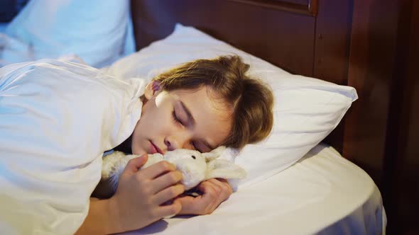 The Pretty Teen Girl Naps with a Plush Toy Sees a Pleasant Sleep and Smiles alt