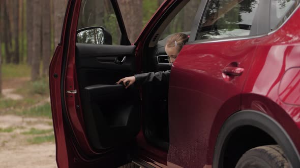 Cute Little Girl Driver Open Car Door and Came Out From the Red Suv Vehicle alt