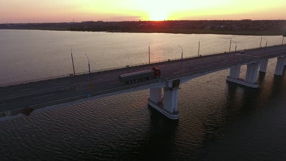 Aerial Shot of a Stretched Bridge Over the Dnipro at Impressionist Sunset in Summer