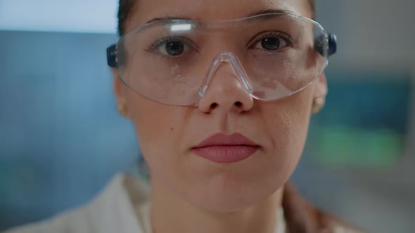 Biochemist with Safety Goggles and White Coat in Laboratory alt