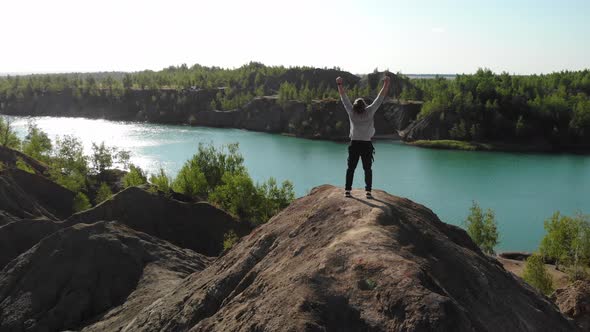 Happy Man in a Gray Sweater and Black Pants Made It to the Top of the Mountain and is Happy About It alt