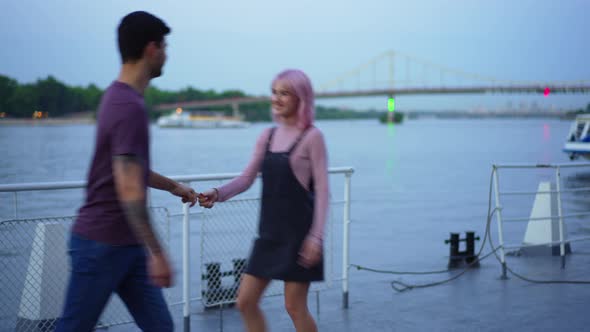 Young Joyful Millennial Couple Dancing on Urban Embankment in the Evening Dating Outdoors alt