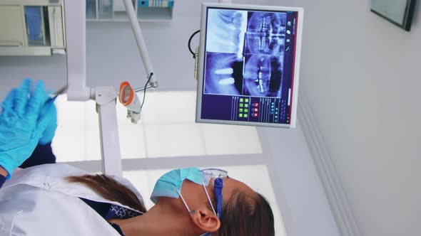 Vertical Video Dentist Doctor and Patient Looking at Digital Teeh Xray alt