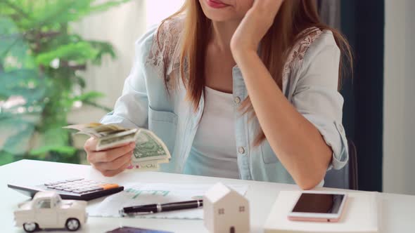 Stressed young woman calculating monthly home expenses