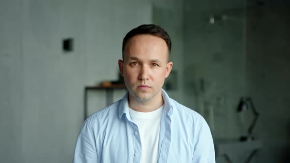 Model man with high temple in white t shirt under blue shirt looks straight alt