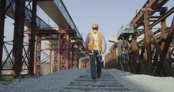 Unrecognizable Builder Walking on Construction Site alt
