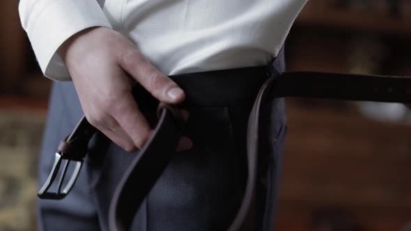 Handsome Groom Fixes His Belt with Pants. Wedding Morning. Businessman alt