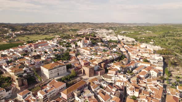 Orbiting shot of  Silves Cathedral and Silves cityscape. Walled fortified town. alt