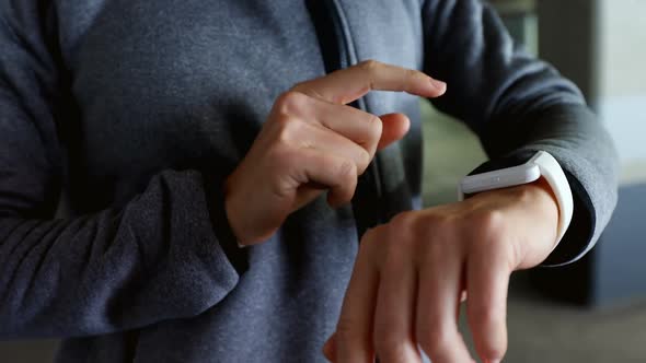Woman using smartwatch at underground car parking lot alt
