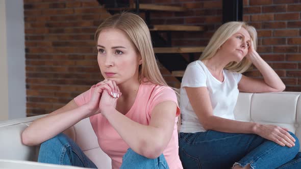 Frustrated Young Adult Woman and Mature Mother Turn Back on Sofa After Conflict alt